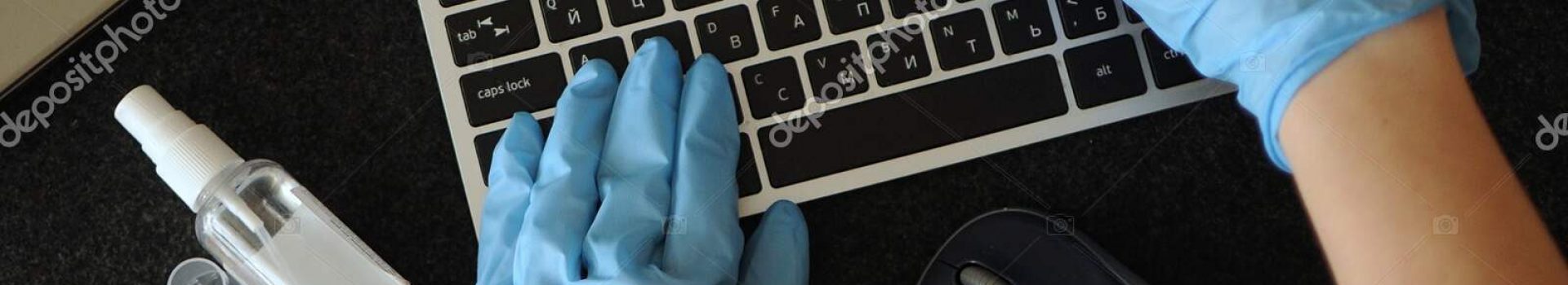 Woman desinfecting workplace devices at home. Preventing disease by sanitazing keyboard